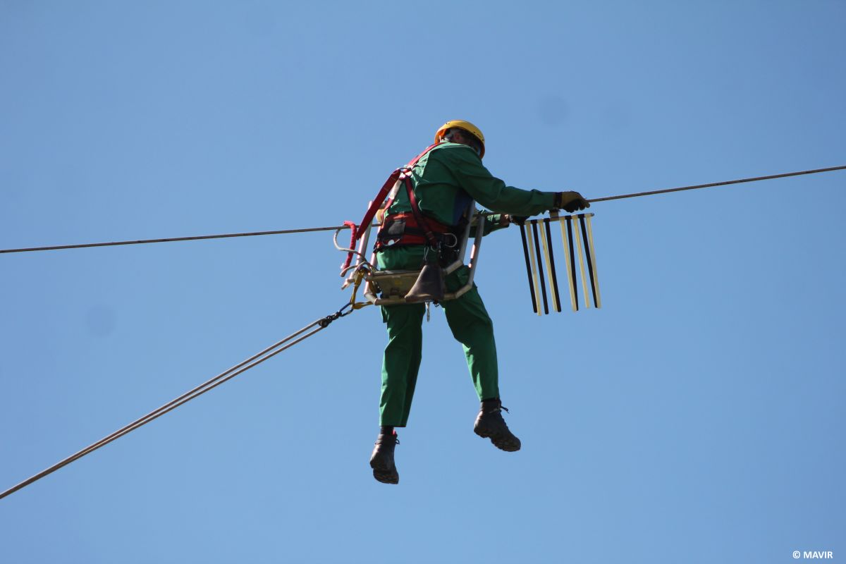 Man installing the flight diverter on the power lines